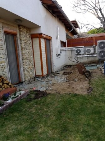 Alapozási munkálatok zajlanak a kertben a gépészeti elemek későbbi eltakarása érdekében.