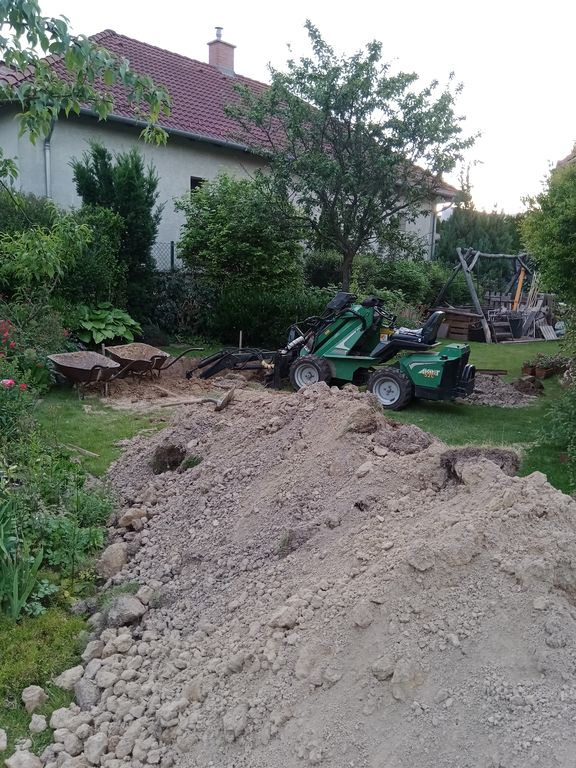AVANT 520 kotrógép földkupacok között kotró adapterrel dolgozik.