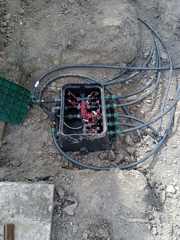 Szelepház mágnesszelepekkel, fittingekkel és csövezéssel egy nyitott gödörben az öntözőrendszer kiépítése során.
